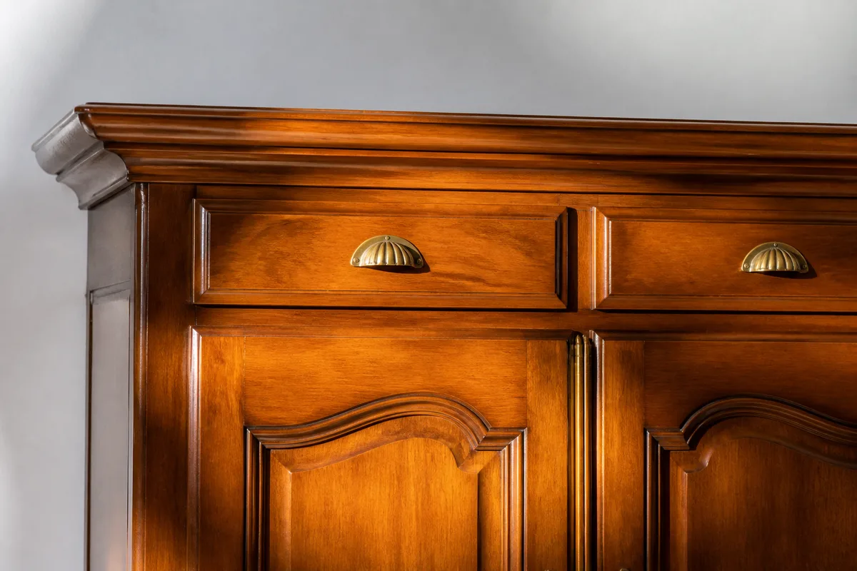 Buffet ancien en merisier verni aux poignees dorees, photographie de face dans une piece claire